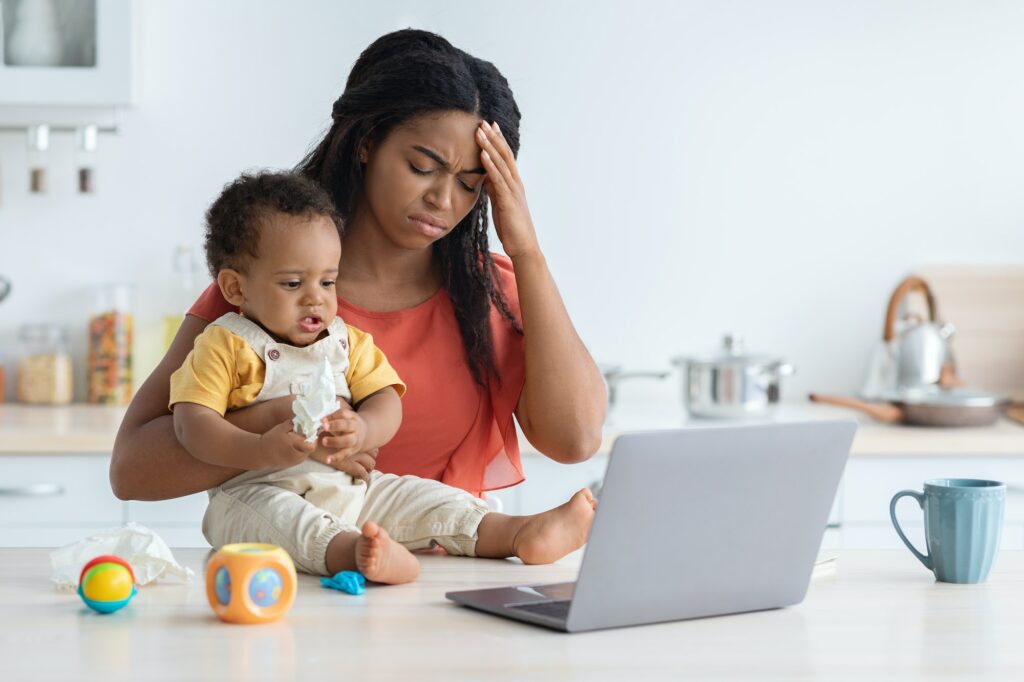 Maternity Stress. Young Black Mother Having Headache While Babysitting Her Infant Child