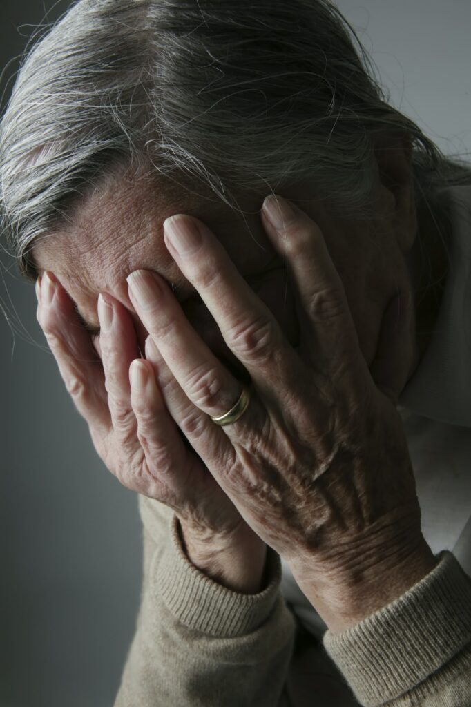Senior woman covering face with her hands